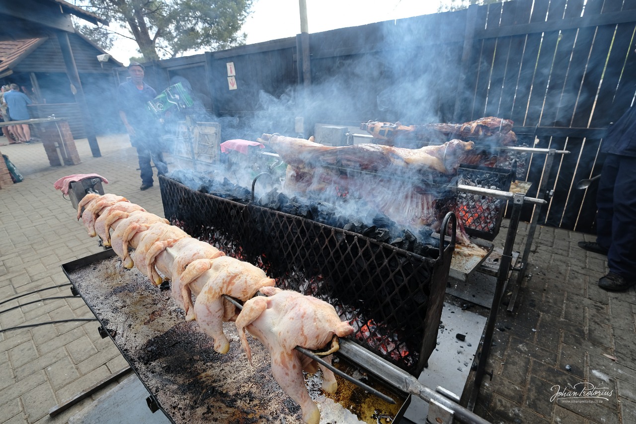 Chickens and meat smoking over the coals